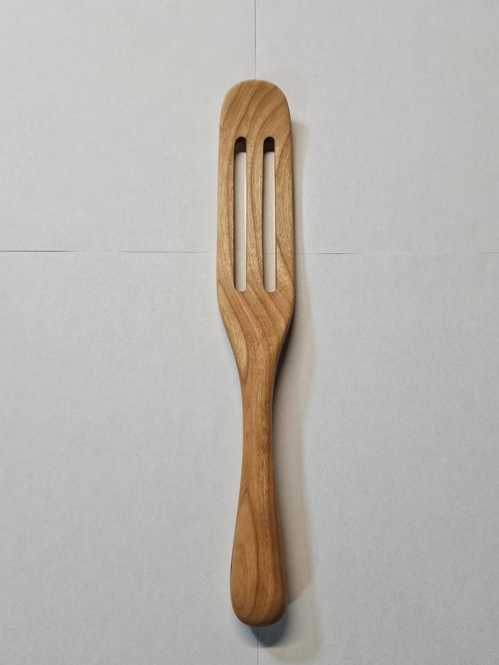 wooden spurtle on a while background