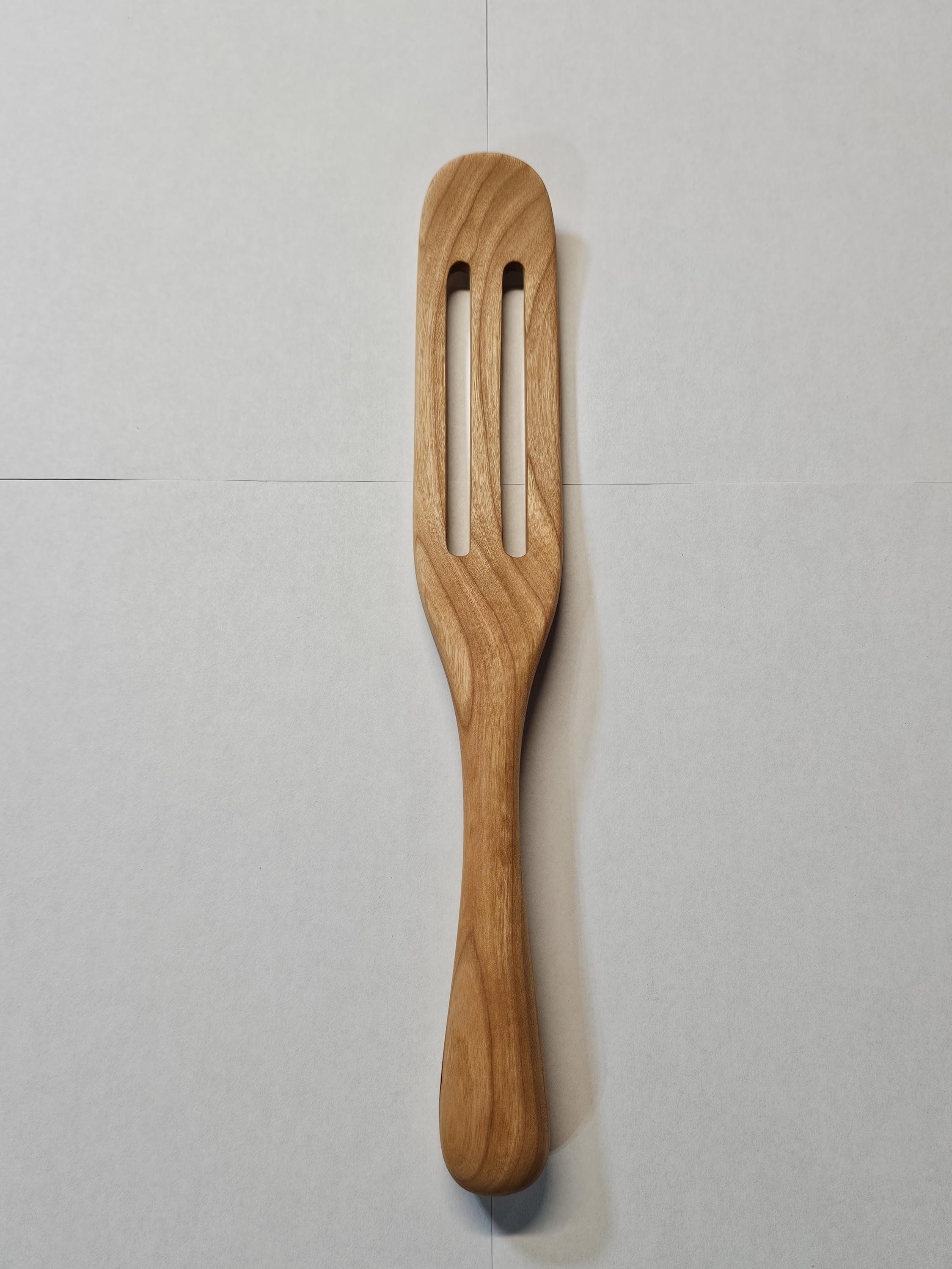 wooden spurtle on a while background