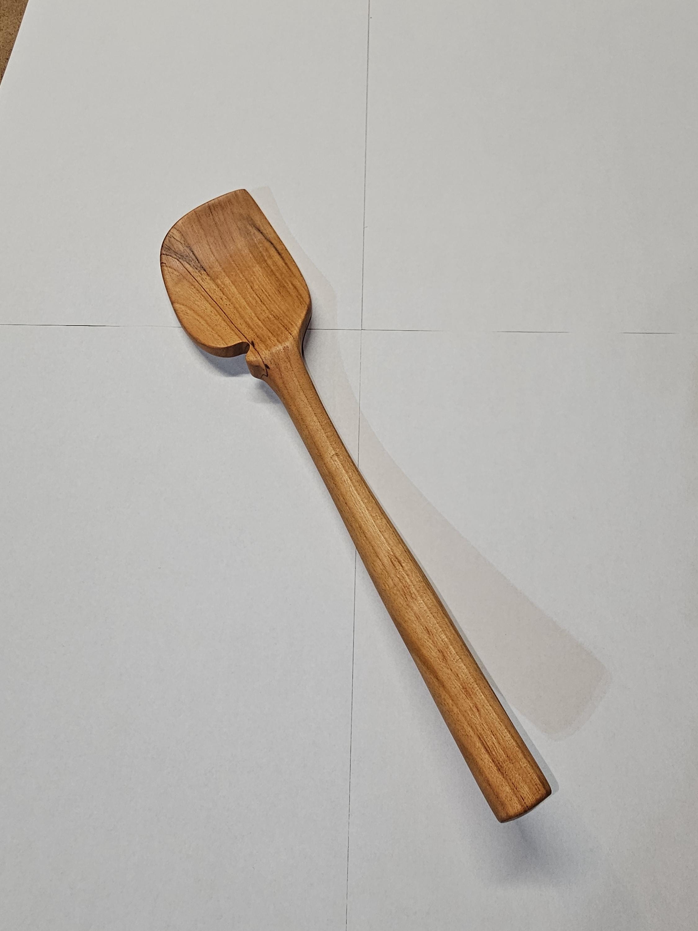 wooden spatula with small notch on white background