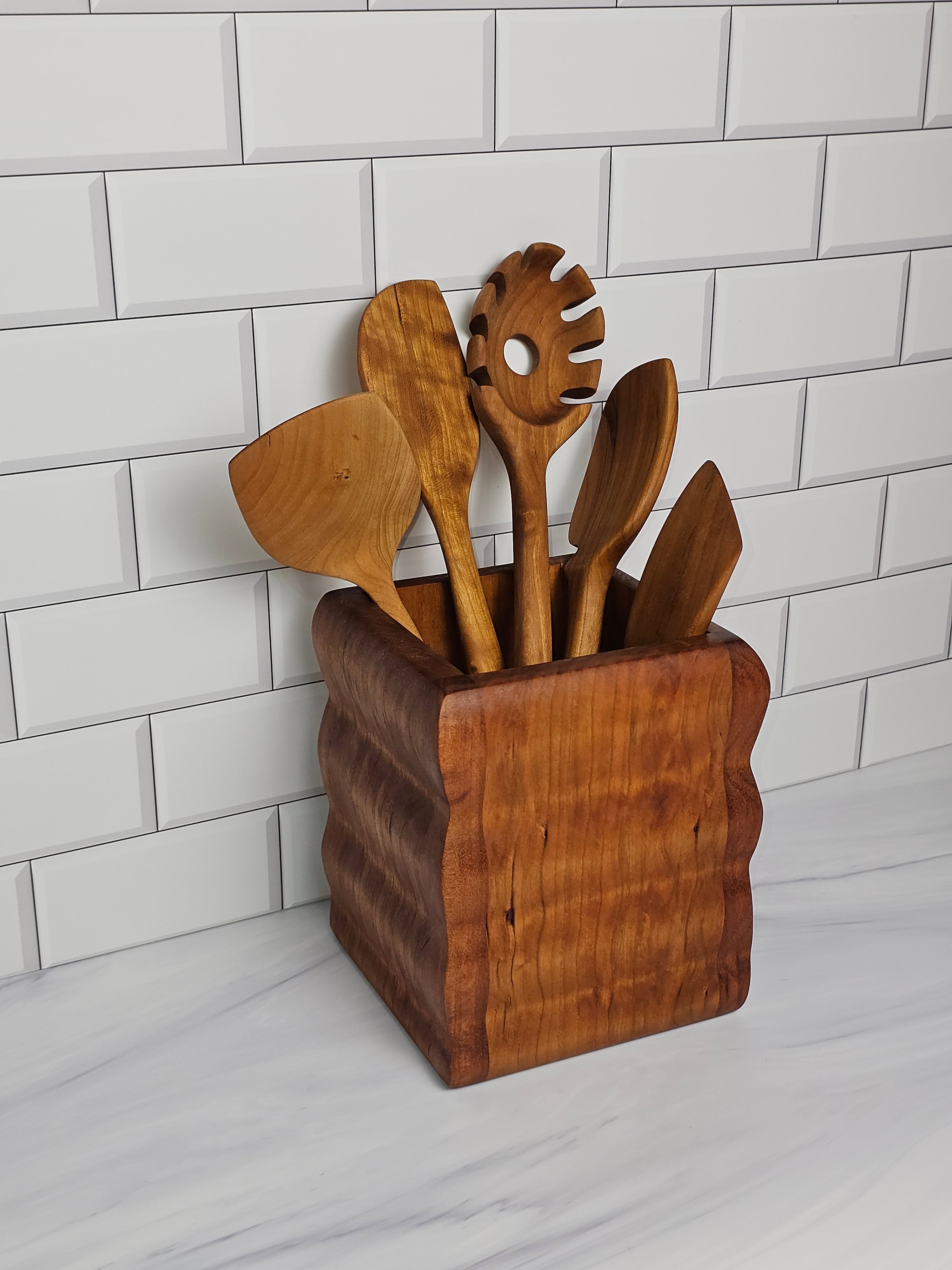 set of wooden kitchen utensils in a wooden countertop utensil holder