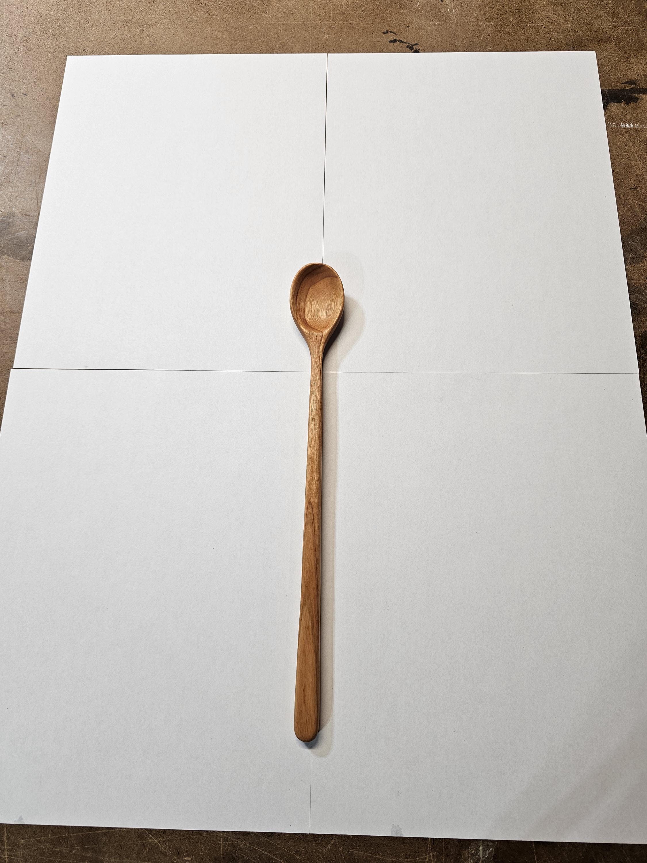 long handled wooden spoon against white background