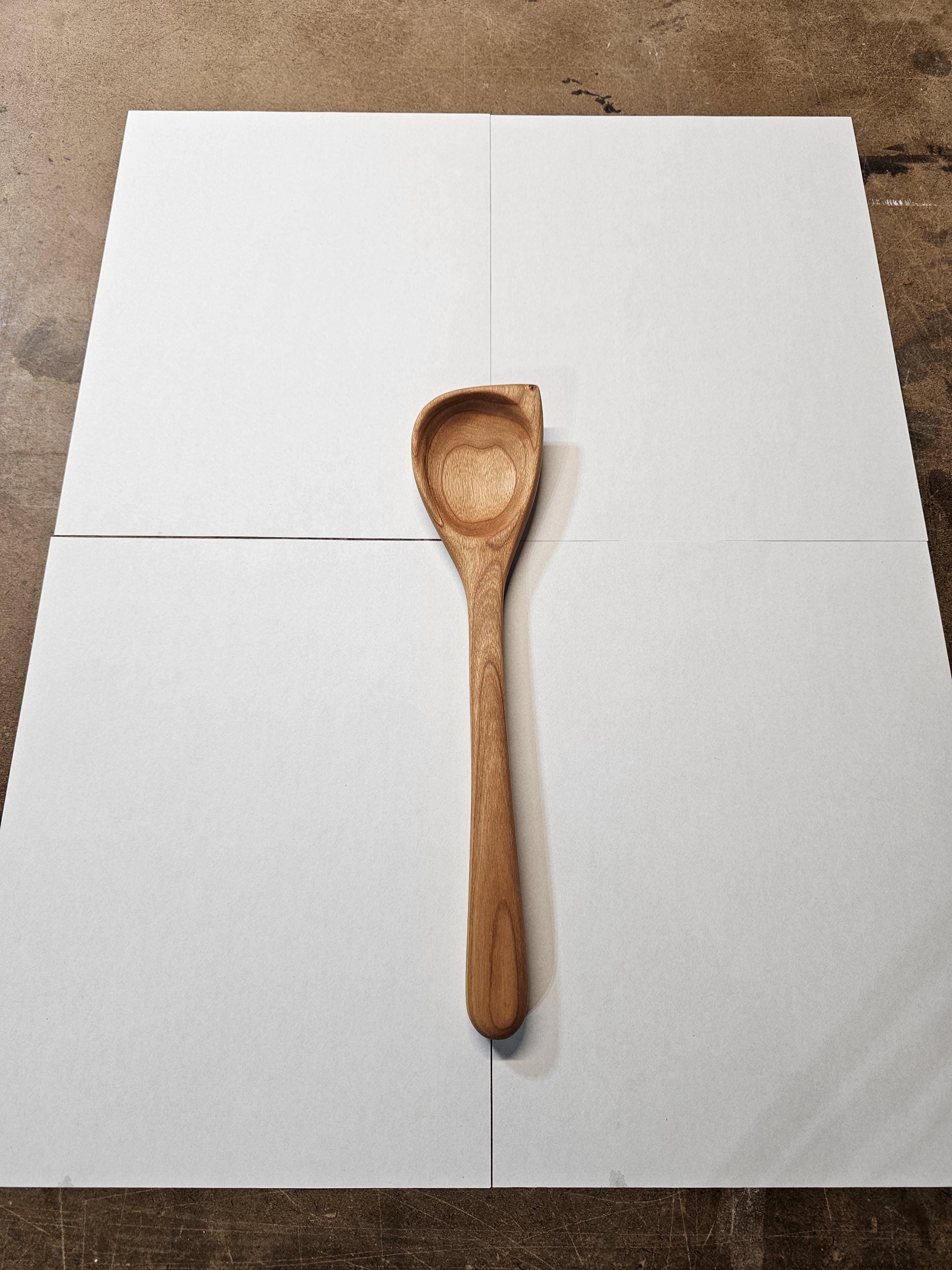 wooden stirring spoon with angled corner on white background