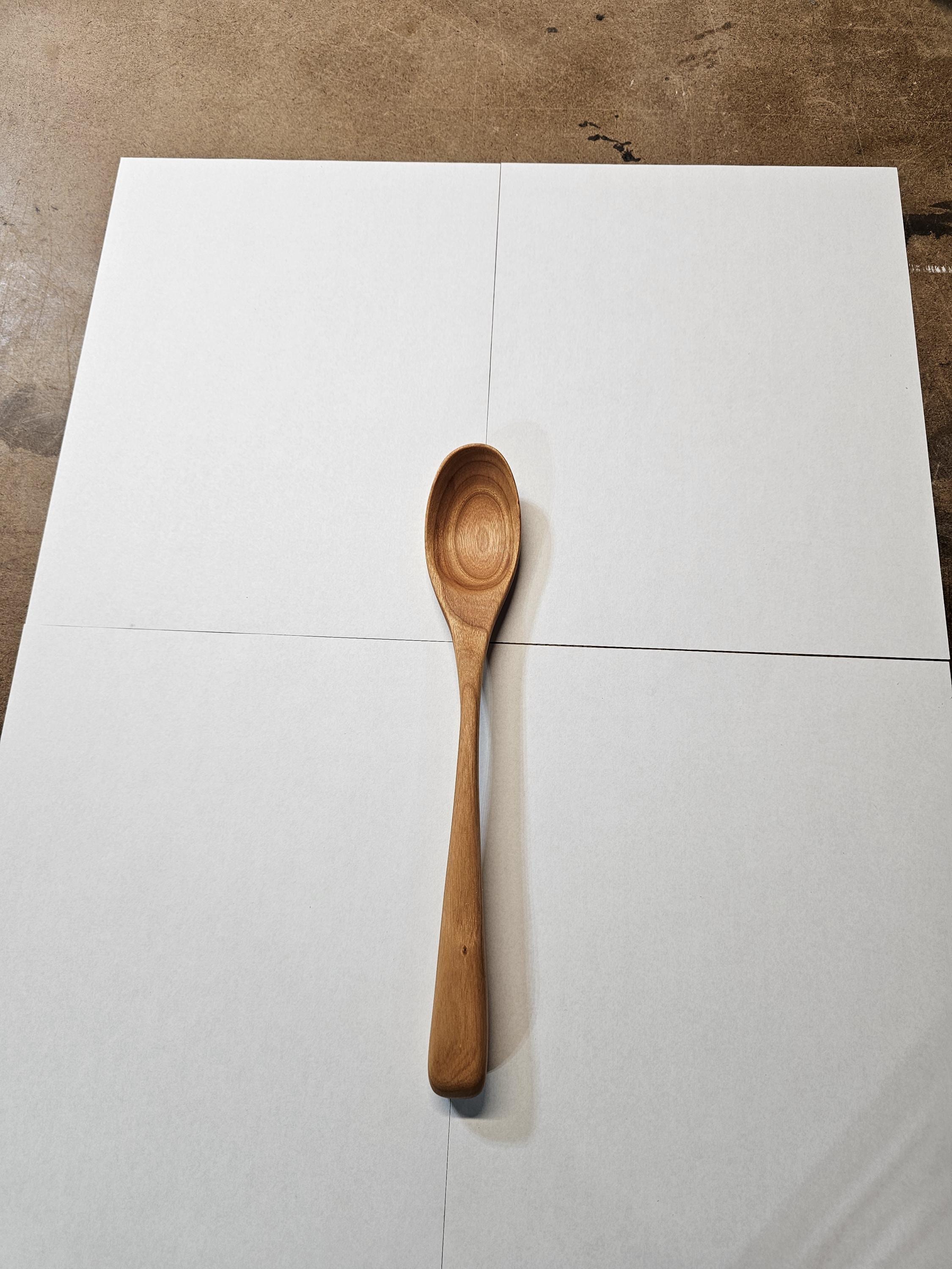 Wooden spoon on a white surface with a brown background